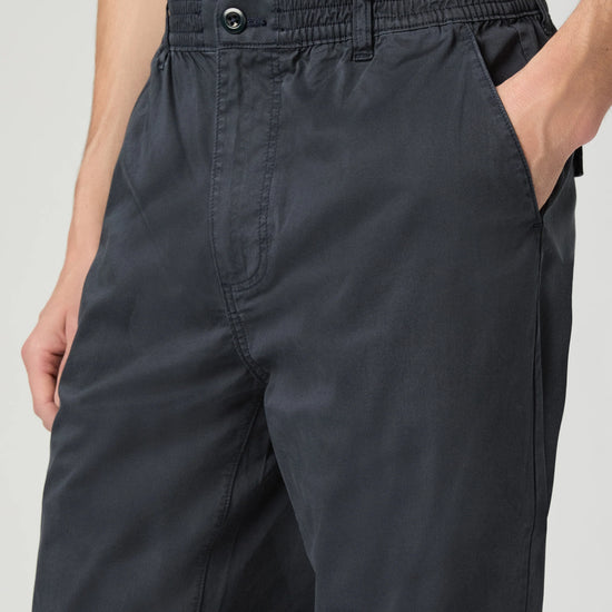Navy pants worn by a person on a light gray background