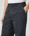 Navy pants worn by a person on a light gray background