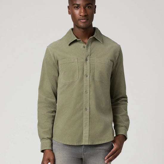 Man wearing green shirt and grey jeans 