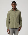Man wearing green shirt and grey jeans 