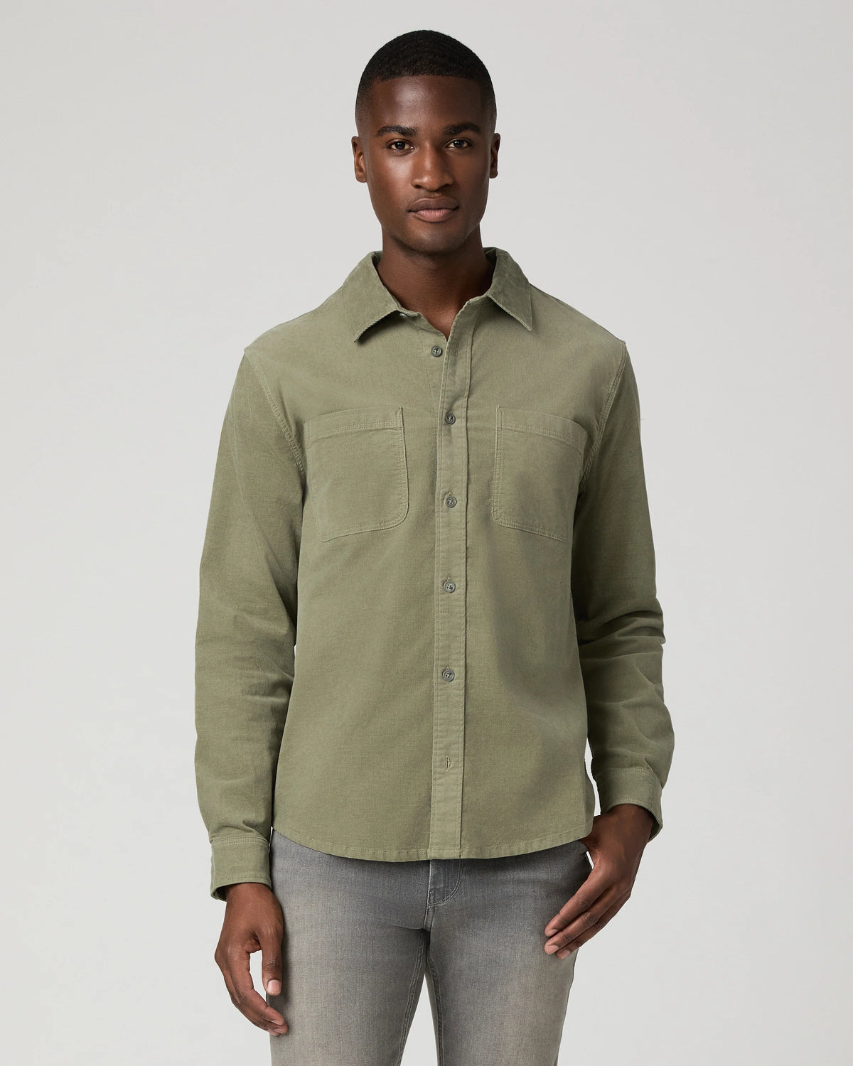 Man wearing green shirt and grey jeans 