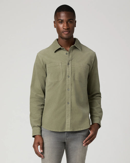 Man wearing green shirt and grey jeans 