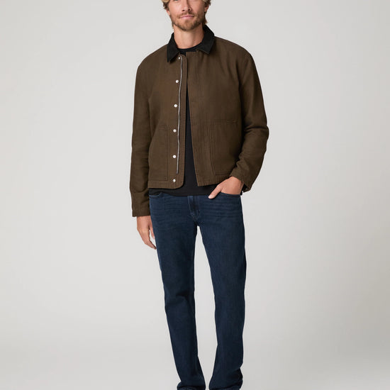Man wearing green jacket and blue jeans 