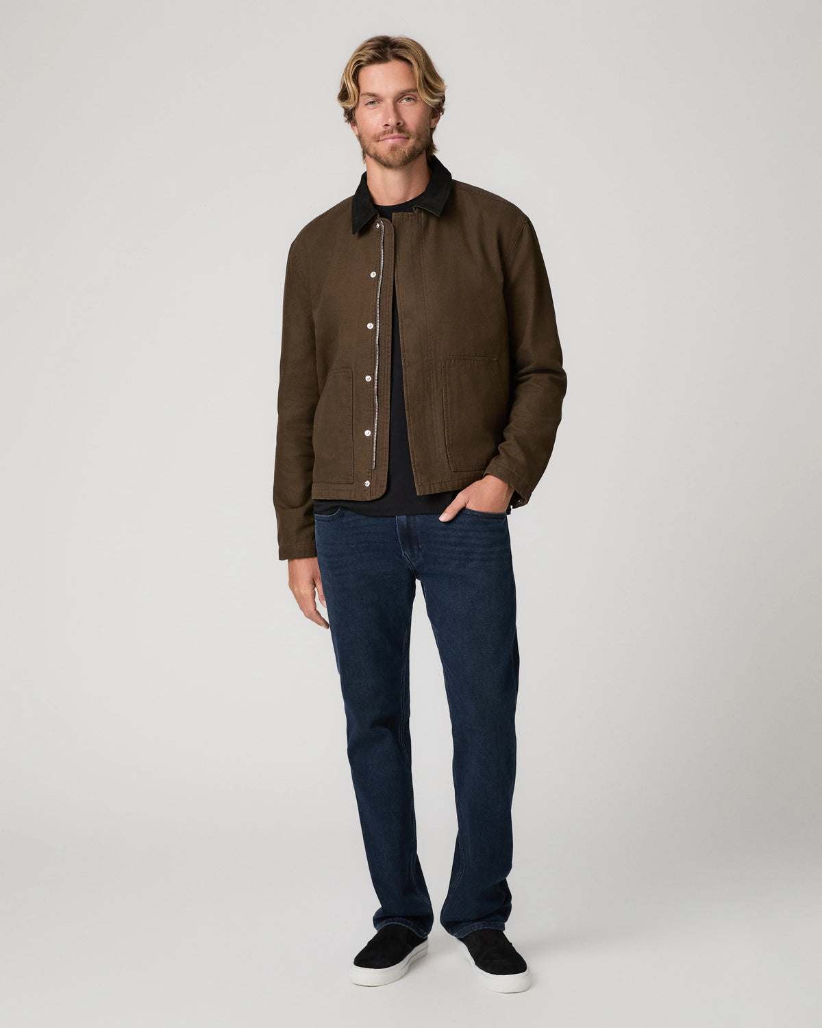 Man wearing green jacket and blue jeans 