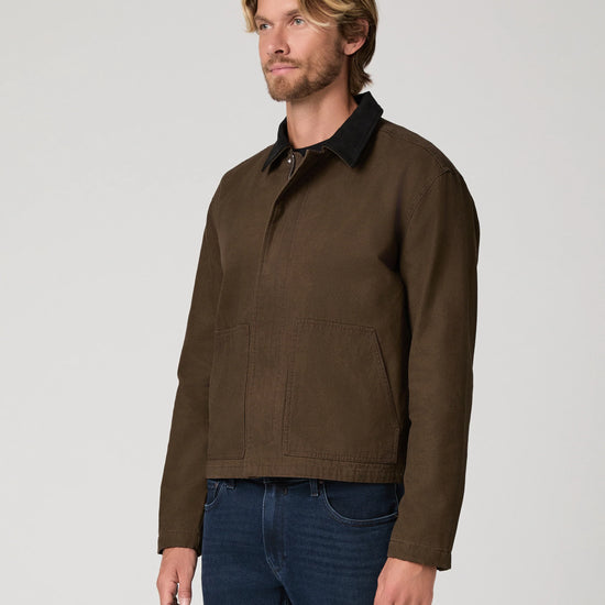 Man wearing green jacket and blue jeans  side view