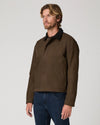Man wearing green jacket and blue jeans  side view