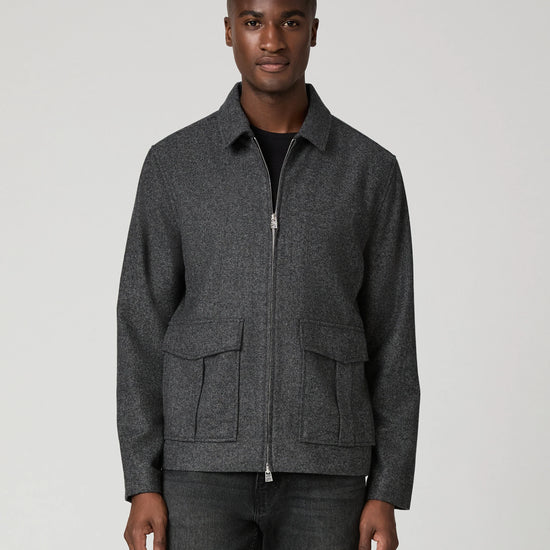 Man wearing grey zip jacket and black jeans 