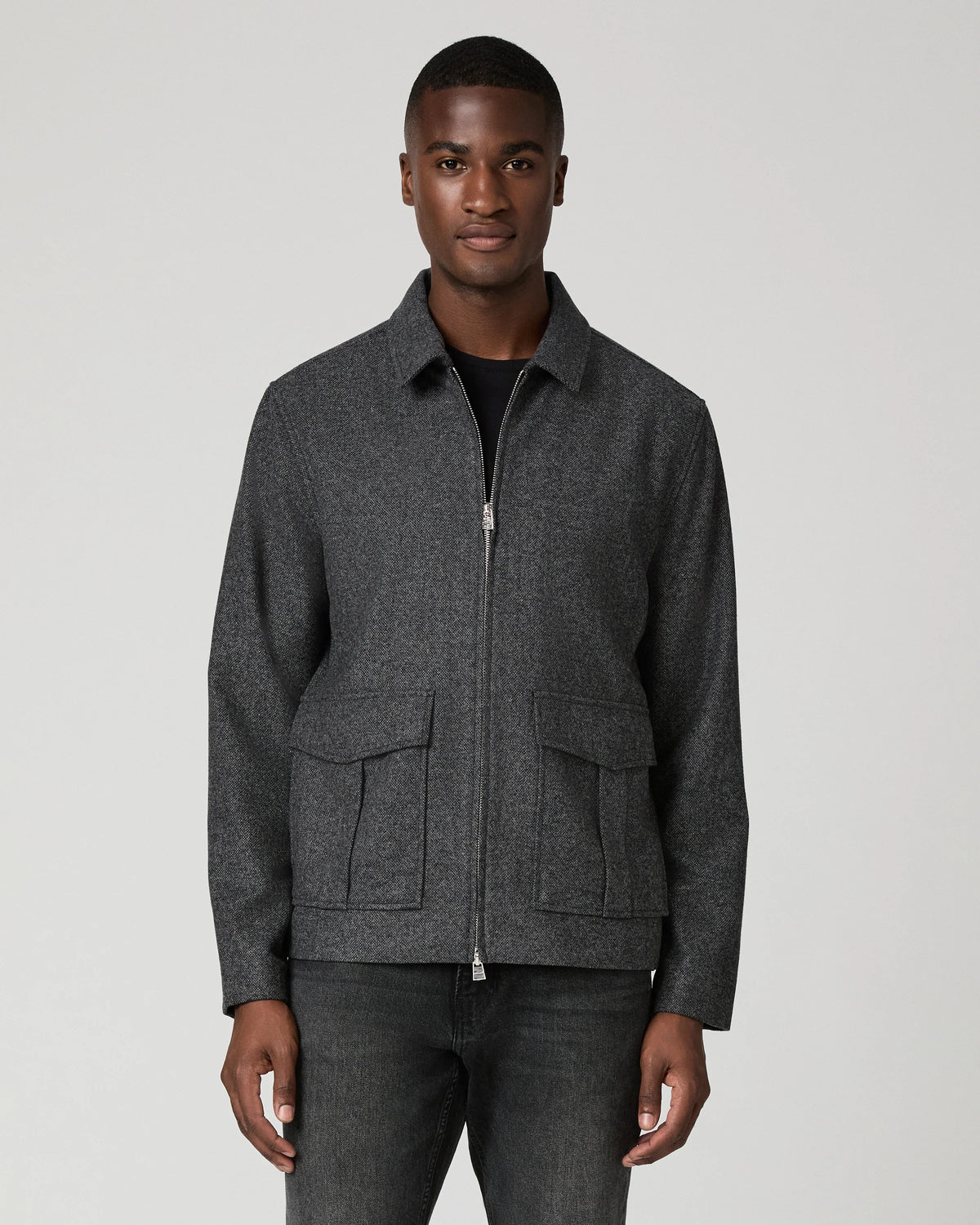 Man wearing grey zip jacket and black jeans 