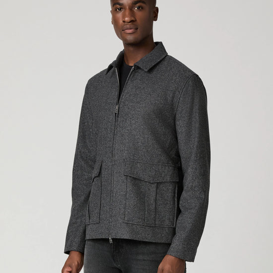 Man wearing grey zip jacket and black jeans  side view
