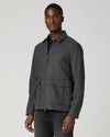 Man wearing grey zip jacket and black jeans  side view
