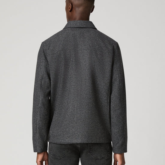 Man wearing grey zip jacket and black jeans  rear view