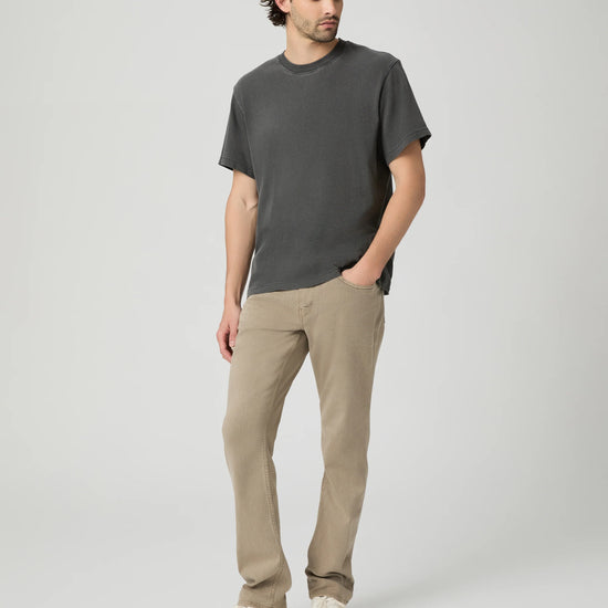 Man wearing a gray t-shirt and beige pants on a white background from Paige