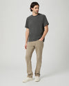 Man wearing a gray t-shirt and beige pants on a white background from Paige