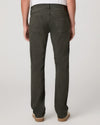 Rear view of a person wearing dark olive green straight-leg jeans with a white shirt and tan shoes, photographed against a light gray studio background.