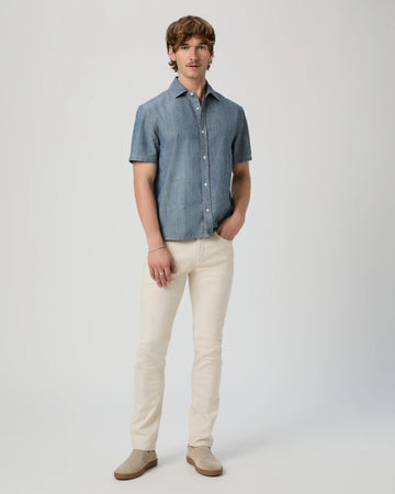 Man wearing a blue checkered shirt and beige pants on a white background from Paige