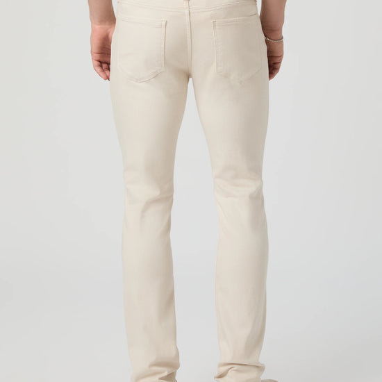 Person wearing beige pants on a plain background from Paige