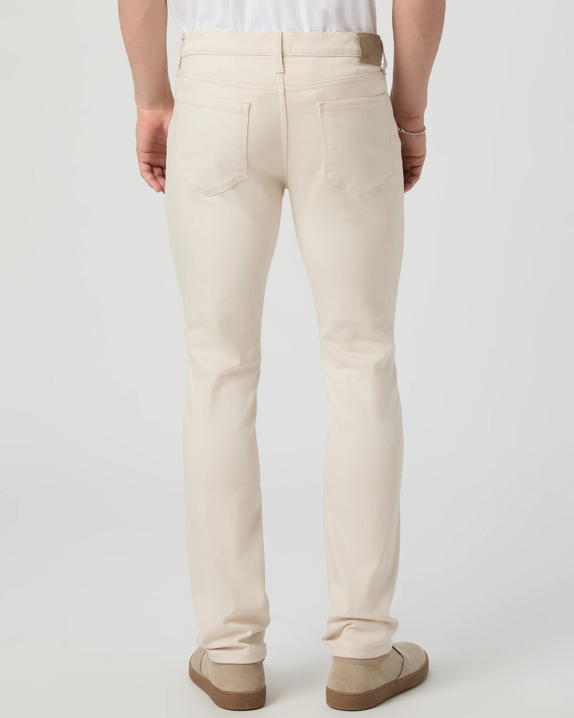 Person wearing beige pants on a plain background from Paige