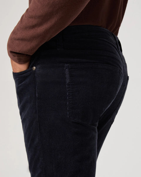 navy blue micro corduroy slim straight leg jeans with metallic hardware from paige close up of rear