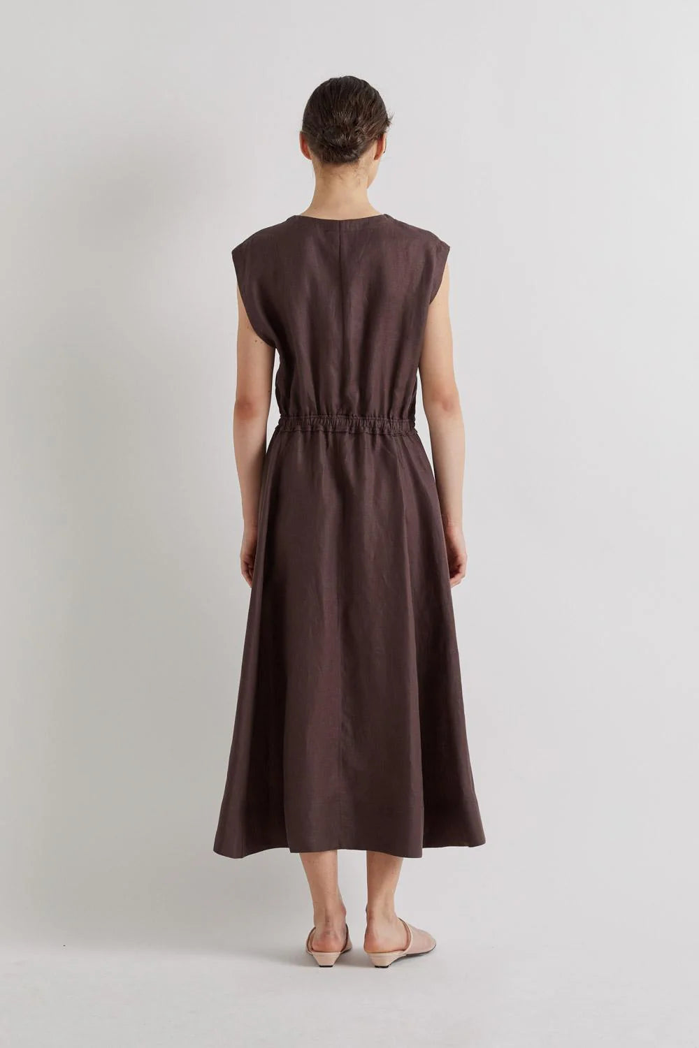 Woman wearing a brown dress on a light gray background from Mei MeiJ