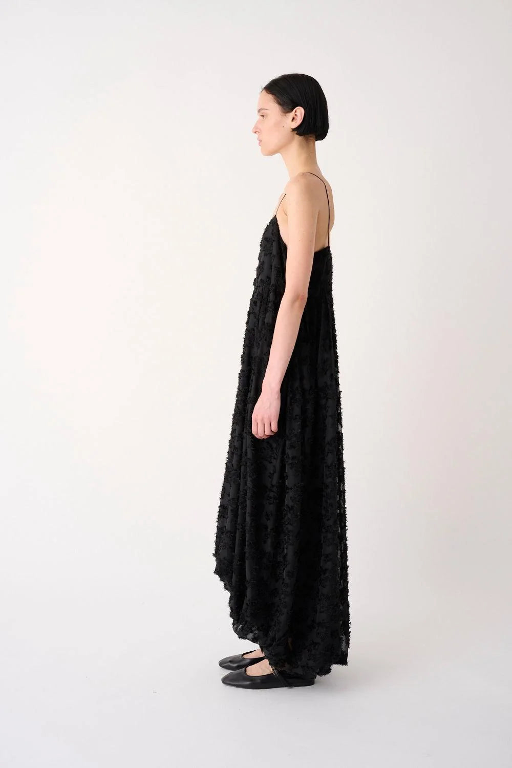 Woman wearing a black floral dress on a white background