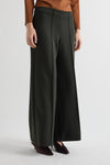 Person wearing dark green wide-leg pants on a light gray background