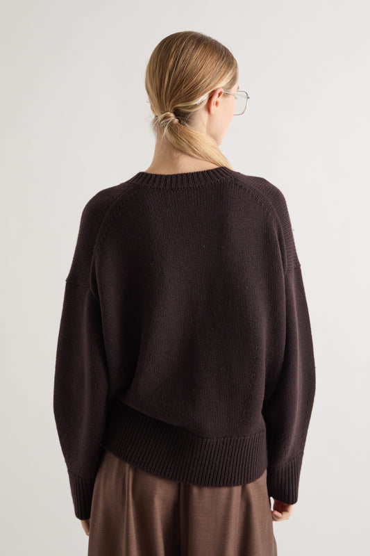 rear view of chocolate brown v neck wool jumper on model