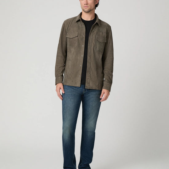 Man wearing a brown suede jacket and blue jeans 