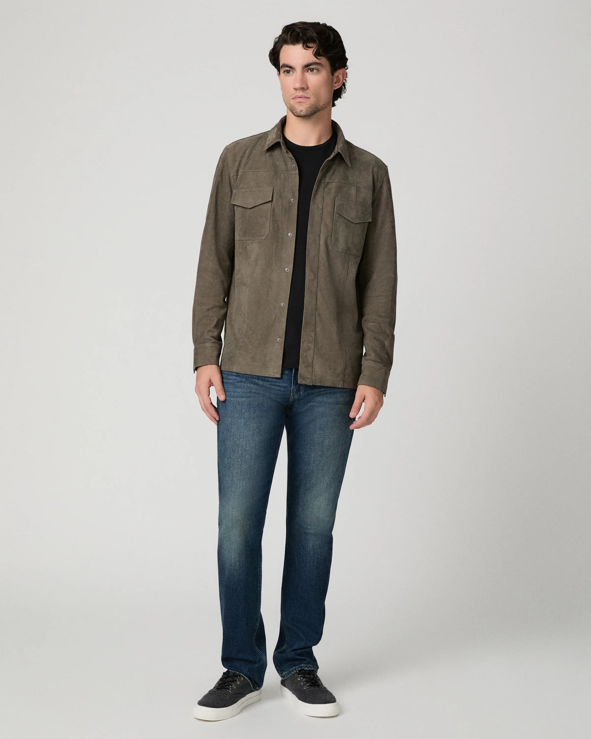 Man wearing a brown suede jacket and blue jeans 