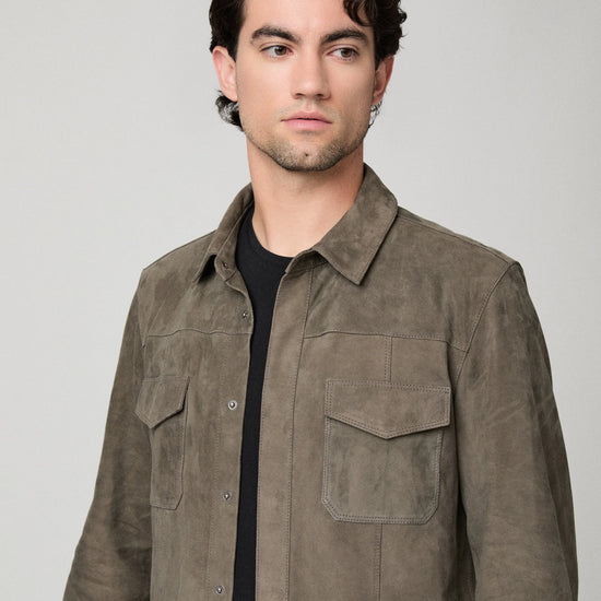 Man wearing a brown suede jacket and blue jeans close up