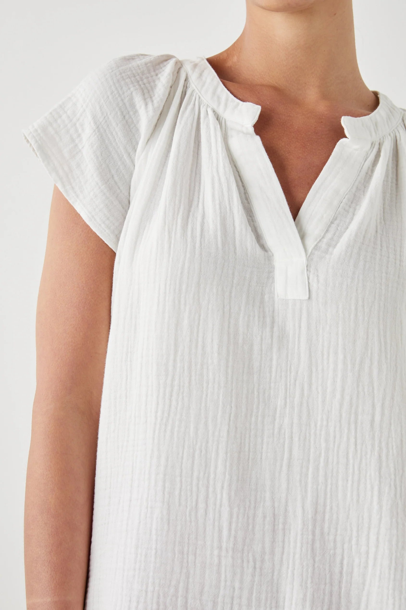 White top in cheese cloth fabric with capped sleeves and a notch neck