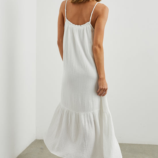 Strappy white cotton muslin dress with tie detail at the neckline and a deep ruffle at the hem rear view