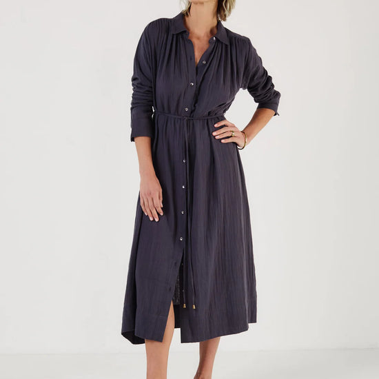 Woman wearing a long dark blue dress by Mondo Corsini on a white background
