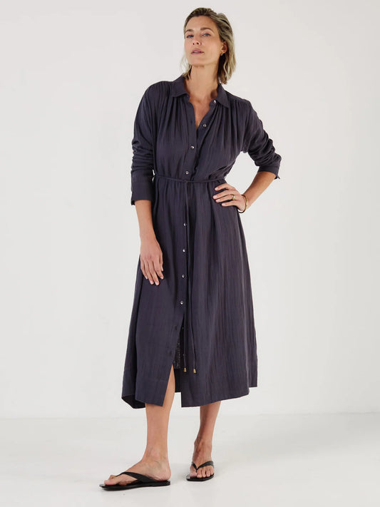 Woman wearing a long dark blue dress by Mondo Corsini on a white background