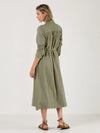 Woman wearing a green dress by Mondo Corsini with a white background. Rear view