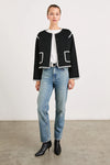 black collarless jacket with white piping/edging  and 2 front patch pockets 