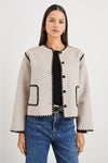 oatmeal collarless jacket with black piping and 2 front patch pockets 