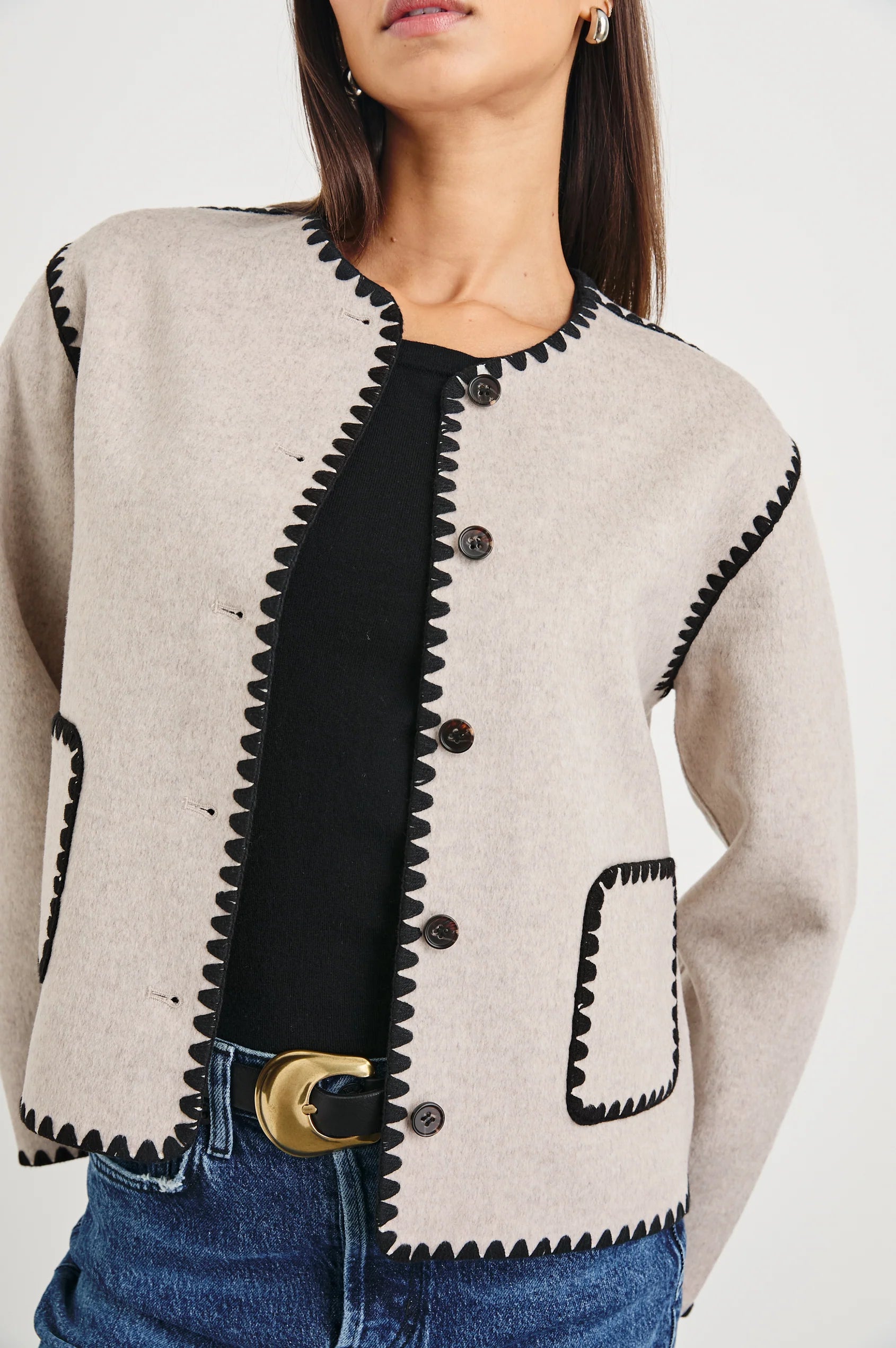 oatmeal collarless jacket with black piping and 2 front patch pockets  close up