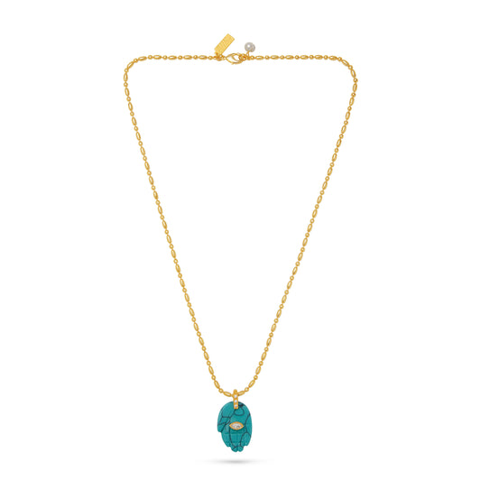 blue hand charm on gold chain necklace flat lay