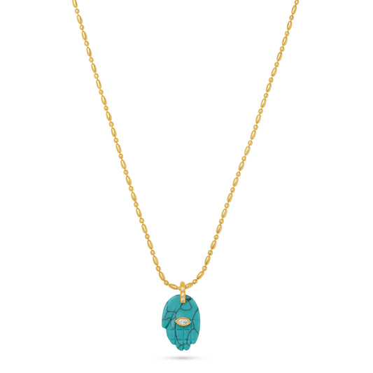 blue hand charm on gold chain necklace flat lay