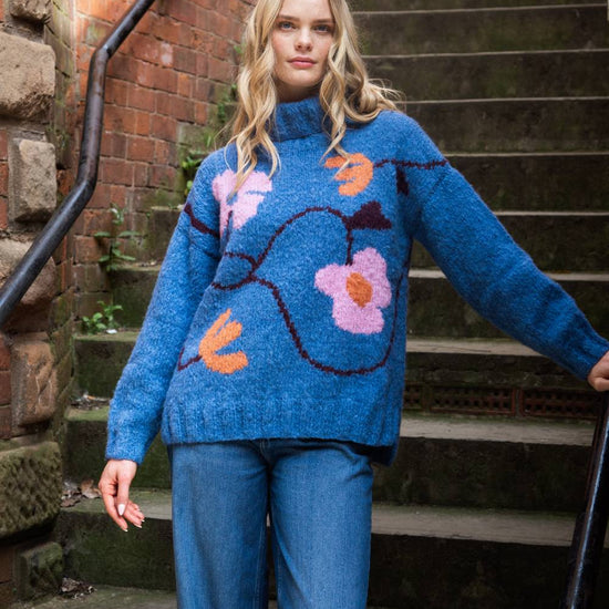 blue roll neck with ribbed cuffs, hem and neck with colourful floral design model shot