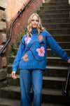 blue roll neck with ribbed cuffs, hem and neck with colourful floral design model shot