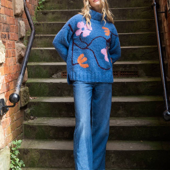 blue roll neck with ribbed cuffs, hem and neck with colourful floral design model shot