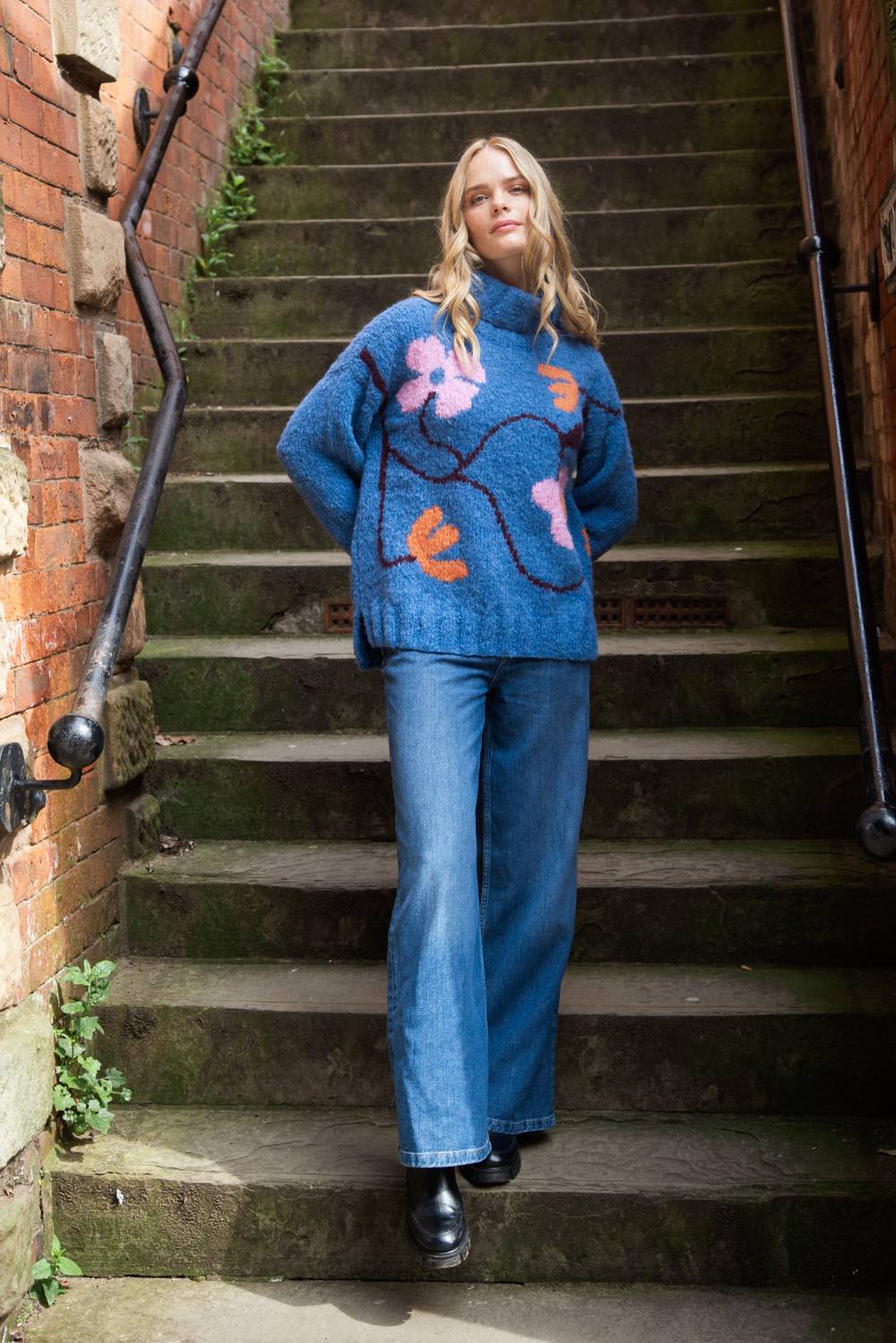 blue roll neck with ribbed cuffs, hem and neck with colourful floral design model shot