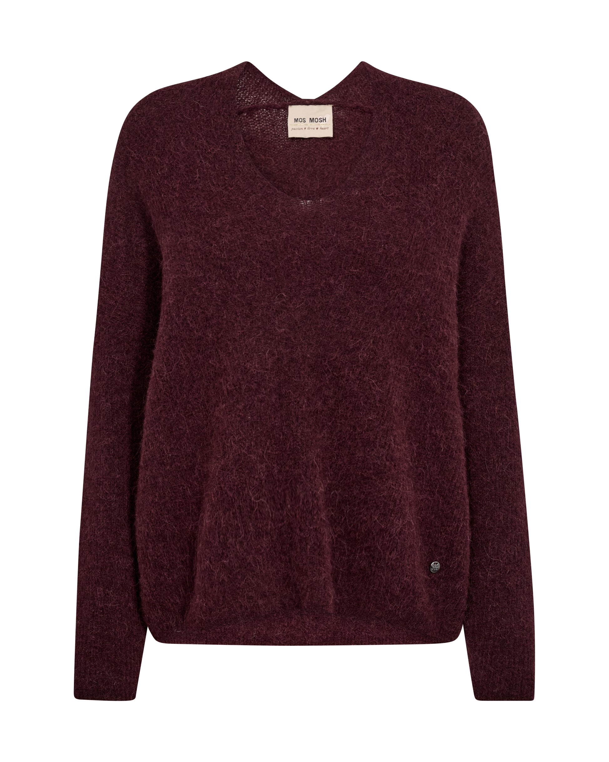 A dark burgundy knit sweater with a crew neck and long sleeves, shown flat against a plain white background. A small beige brand label is visible at the inner collar, and a tiny dark button detail is near the lower right hem.