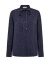 A dark navy blue long-sleeve button-up shirt with a subtle tonal leopard print and a tie-neck collar, shown against a plain white background.