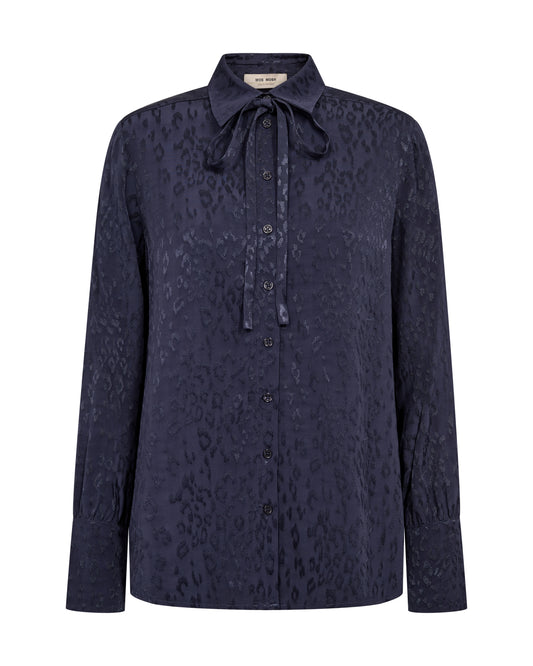 A dark navy blue long-sleeve button-up shirt with a subtle tonal leopard print and a tie-neck collar, shown against a plain white background.