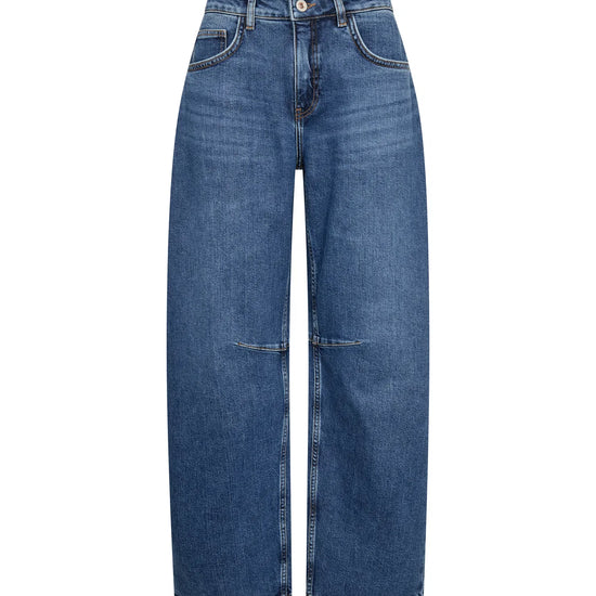 flat lay of blue barrel leg shape jeans on white background 