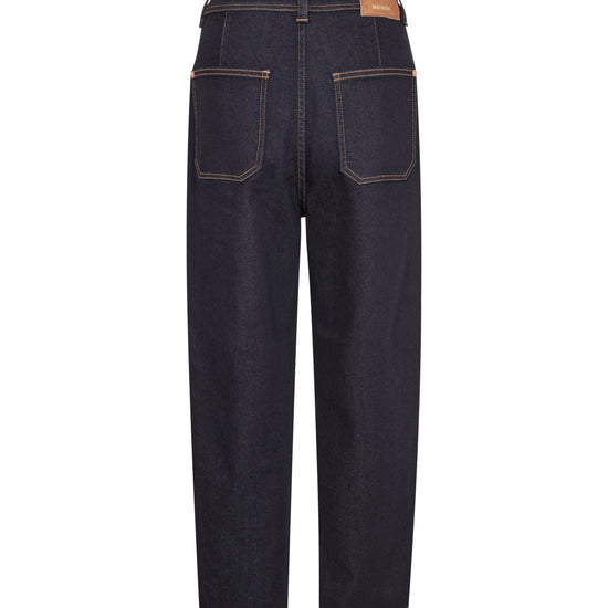 Back view of dark indigo denim jeans with contrast tan stitching and a brown leather patch on the back waistband, shown on a plain white background.