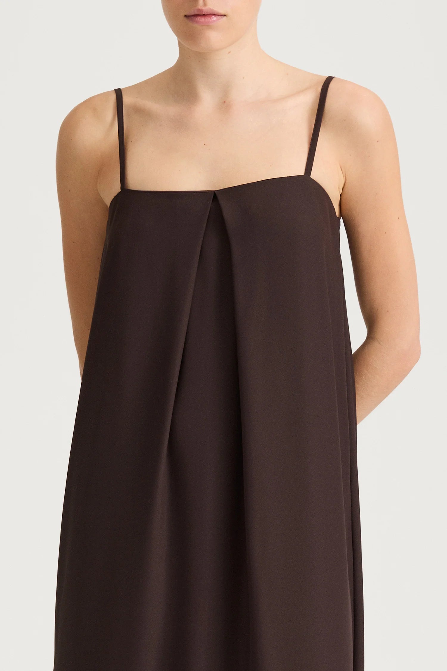 Brown slip dress with thin straps on a white background
