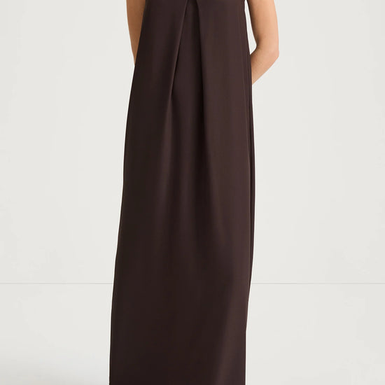 Woman wearing a long brown dress on a white background